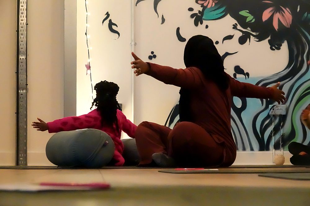 A mum and her daughter stretching together